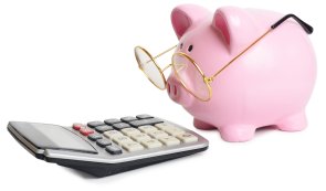 Sparschwein mit Brille vor einem Taschenrechner Sparschwein mit Brille vor einem Taschenrechner